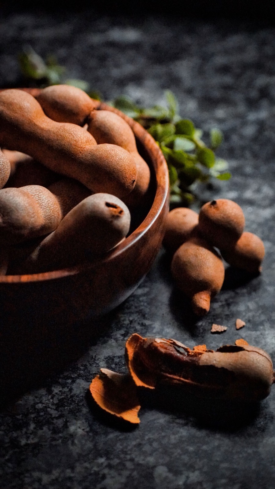 Tamarind pods in a wooden bowl